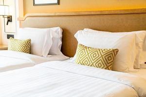 Cómoda decoración de almohadas en la cama en la habitación del hotel foto