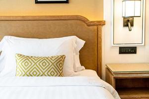 Cómoda decoración de almohadas en la cama en la habitación del hotel foto