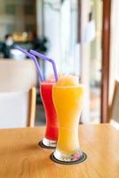 Batido de naranja y vaso de batido de sandía en café restaurante foto