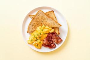 huevos revueltos con pan tostado y tocino para el desayuno foto