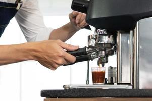 Close up picture of coffee maker machine brewing expresso into a cup in the restaurant. barista and coffee shop concept photo