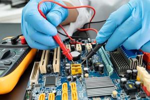 E-waste, technician repairing inside of hard disk by soldering iron. Integrated Circuit. the concept of data, hardware, technician and technology. photo