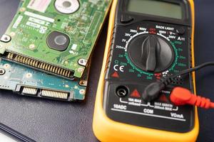 Multimeter with main board, maintenance, repairing and checking computer hardware concept. photo