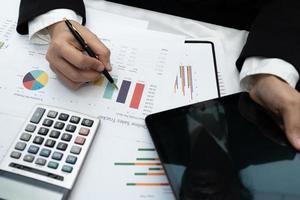 Asian accountant working and analyzing financial reports project accounting with chart graph and calculator in modern office,finance and business concept.