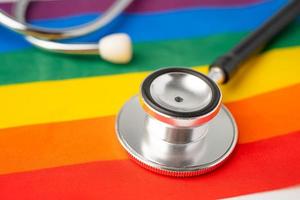 Black stethoscope on rainbow flag background, symbol of LGBT pride month celebrate annual in June social, symbol of gay, lesbian, bisexual, transgender, human rights and peace. photo