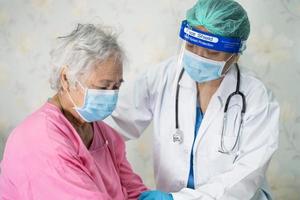 médico que revisa el paciente asiático mayor o anciano que usa una mascarilla en el hospital para proteger la infección del coronavirus covid-19. foto