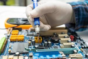 Technician repairing inside of hard disk by soldering iron. Integrated Circuit. The concept of data, hardware, technician and technology. photo