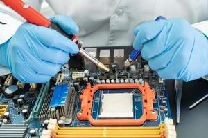 Technician repairing inside of hard disk by soldering iron. Integrated Circuit. The concept of data, hardware, technician and technology. photo