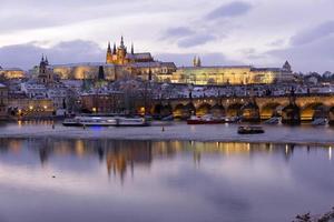 Noche de Navidad nevada colorida ciudad menor de Praga con el castillo gótico y el puente de Carlos, República Checa foto