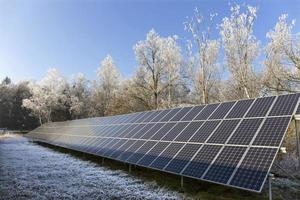 Estación de energía solar en la naturaleza nevada del invierno congelado foto