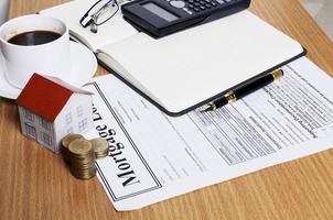 House paper with coins stack on mortgage application form on worktable photo