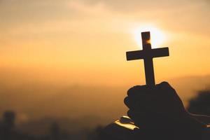 manos de una mujer cristiana sosteniendo una cruz mientras reza a dios creencias religiosas, espacio de copia. foto