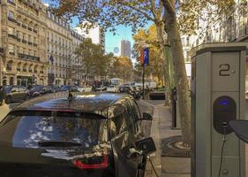Electric car charging down a street in Paris, France