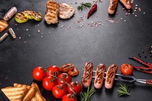 Tasty, fresh sausages grilled with vegetables spices and herbs photo