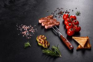 Tasty, fresh sausages grilled with vegetables spices and herbs photo
