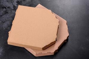 Caja de cartón marrón de forma cuadrada para transporte y entrega de pizza. foto