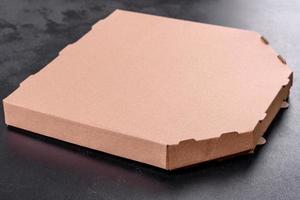 Caja de cartón marrón de forma cuadrada para transporte y entrega de pizza.