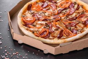 Fresh delicious pizza made in a hearth oven with sausage, pepper and tomatoes photo