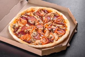 Fresh delicious pizza made in a hearth oven with sausage, pepper and tomatoes photo
