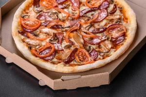Fresh delicious pizza made in a hearth oven with sausage, pepper and tomatoes photo