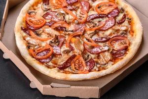 Fresh delicious pizza made in a hearth oven with sausage, pepper and tomatoes photo