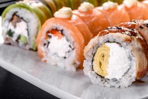 Rollos de sushi frescos y sabrosos dispuestos en forma de dragón con jengibre y wasabi