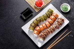 Fresh tasty sushi rolls laid out in the form of a dragon with ginger and wasabi photo