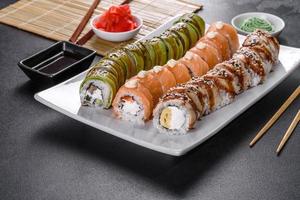 Fresh tasty sushi rolls laid out in the form of a dragon with ginger and wasabi