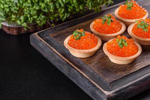 Delicious fresh red caviar on a dark concrete table photo