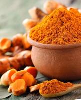 Turmeric roots in the basket on wooden table photo