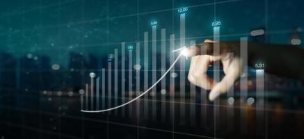 Double exposure of business mans hand pointing to arrow graph and chart photo