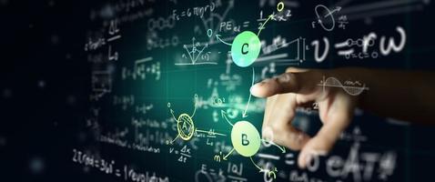 Hand on science formula and math equation on abstract blackboard photo