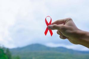 cinta de conciencia del día mundial del sida en manos femeninas foto