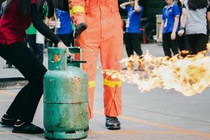 capacitación de los empleados sobre extinción de incendios, cierre la válvula del tanque de gas que se enciende. foto
