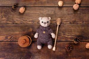 Toy bear tied from woolen threads on a dark background photo