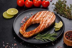 Fresh cooked delicious salmon steak with spices and herbs baked on a grill photo