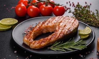 Fresh cooked delicious salmon steak with spices and herbs baked on a grill photo