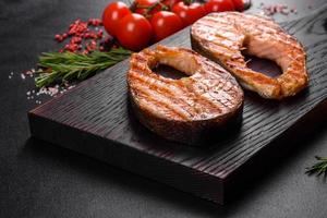 Fresh cooked delicious salmon steak with spices and herbs baked on a grill photo