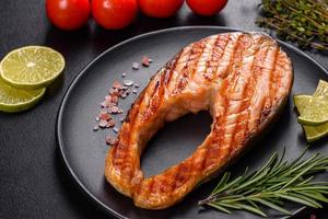 Fresh cooked delicious salmon steak with spices and herbs baked on a grill photo