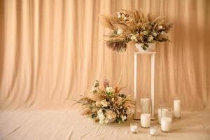 Decorations from dry beautiful flowers in a white vase on a beige fabric background photo