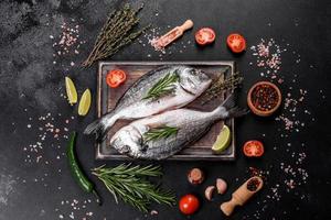 Raw dorado fish with spices cooking on cutting board. Fresh fish dorado photo