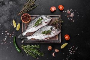 Raw dorado fish with spices cooking on cutting board. Fresh fish dorado photo