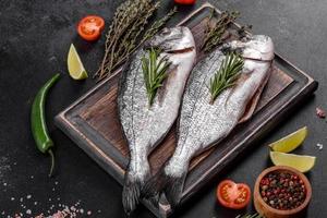 Raw dorado fish with spices cooking on cutting board. Fresh fish dorado photo