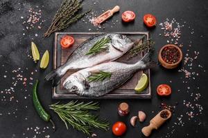 Raw dorado fish with spices cooking on cutting board. Fresh fish dorado photo