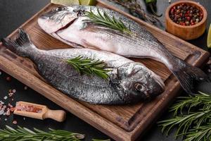 Raw dorado fish with spices cooking on cutting board. Fresh fish dorado photo