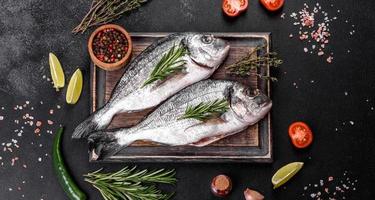 Raw dorado fish with spices cooking on cutting board. Fresh fish dorado photo