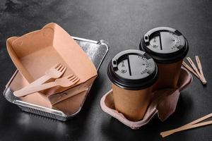 Disposable dishes made of environmentally friendly brown cardboard on a dark background photo