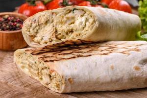 Delicious fresh shawarma with meat and vegetables on a dark concrete table photo