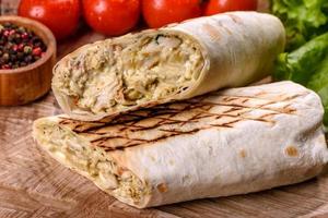 Delicious fresh shawarma with meat and vegetables on a dark concrete table photo