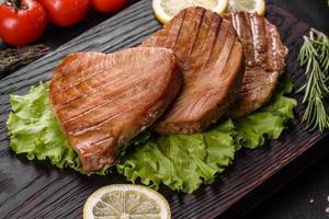 Delicious juicy tuna steak grilled with spices and herbs photo